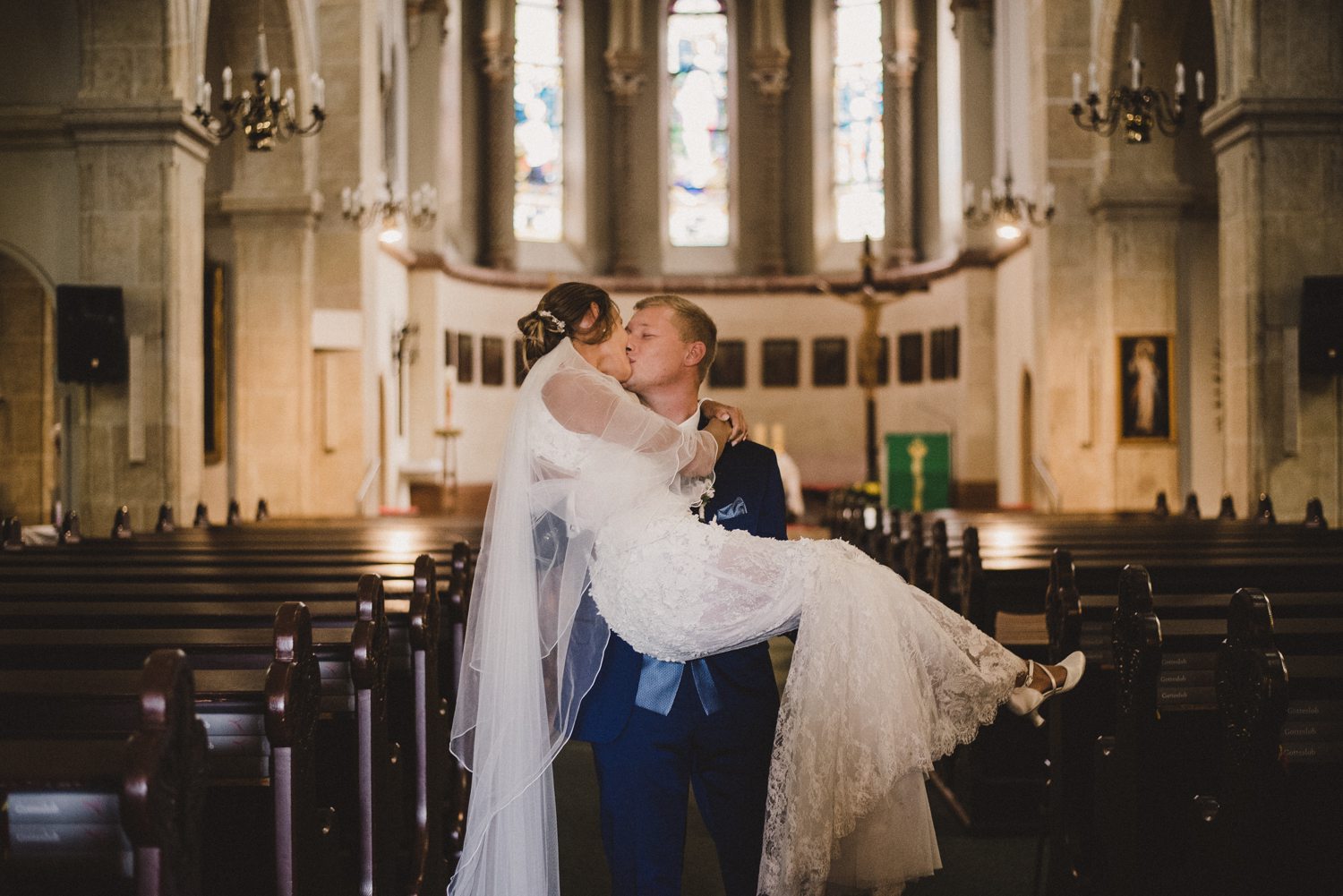 Für die Hochzeitsreportage küsst sich das Brautpaar in der Kirche